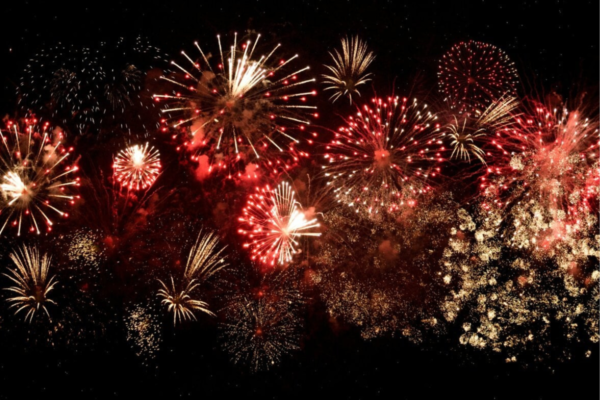 red and white fireworks in going off in night sky